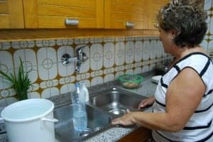 Una montisonense intenta llenar una botella de agua. Foto JLP.