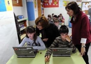 La consejera Broto observa a dos alumnos con tablets PC. Foto S.E.