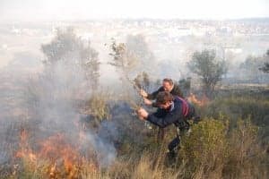 Dos vecinos tratan de apagar el incendio. JLP.
