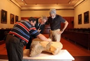 Los arqueólogos junto a la escultura. 