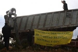 Miembros de Ecologistas en Acción saltando la valla cinegética ilegal de FIMBAS  para poder acceder al monte público.