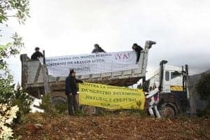 Acto de protesta sobre uno de los vehículos con los que FIMBAS obstaculiza la entrada de la maquinaria del Gobierno de Aragón al monte público.