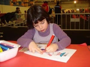 Una niña pone su granito para colgarlo en el estand. Foto: S.E.