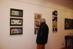 Un visitante observa los cuadros y fotos de la muestra. JLP.