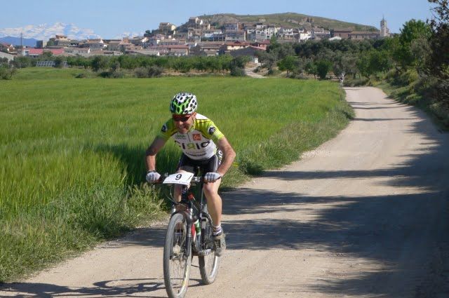 Un esforzado corredor deja atras, a golpe de pedal, el caserio de Estadilla.