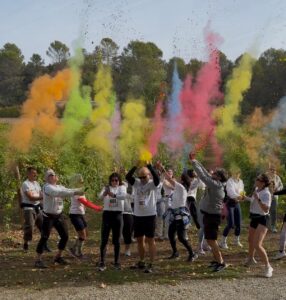 Participantes lanzan polvos de colores entre los viñedos de Viñas del Vero durante la primera actividad de Experiencias Somontano.