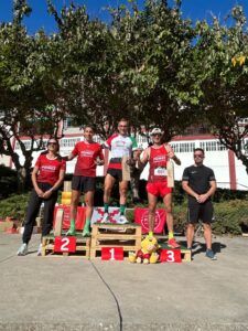 Los tres primeros clasificados del VII Cross Pómez Barbastro posan en el podio con sus trofeos.